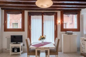 Un coin repas comprenant une table, des chaises, un téléviseur et un radiateur.