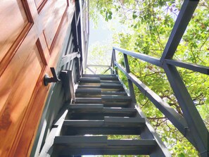 Un escalier en bois menant à un bâtiment doté de rampes en métal.