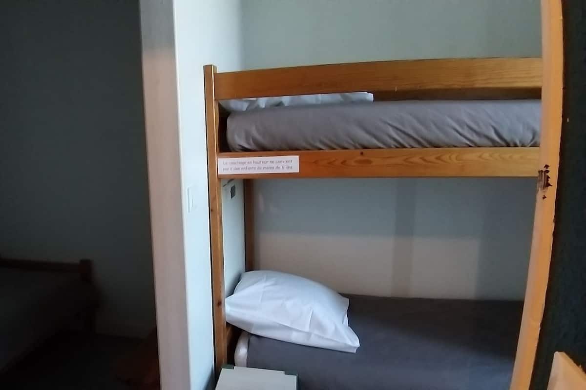 Una cama litera con un letrero que advierte sobre la altura.