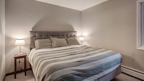 A bedroom with a bed, two bedside lamps, and a window. - 2bd_mw_315 (Frisco)