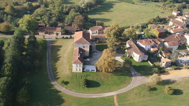 An aerial view of a rural village with houses, roads, and green fields. - Le Presbytère (Hontanx)