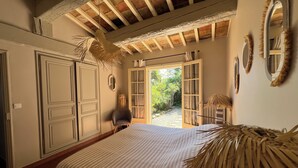 A bedroom with a bed, a chair, a wardrobe, and a view of the outdoors. - Very nice villa with infinity pool, sea view, harbor, Cavalaire (Cavalaire-Sur-Mer)