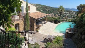 A stone villa with a swimming pool, outdoor seating, and a view of the surrounding hills. - Very nice villa with infinity pool, sea view, harbor, Cavalaire (Cavalaire-Sur-Mer)