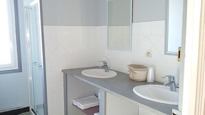 A bathroom with two sinks, a mirror, and a shower. - La Poste (Hontanx)