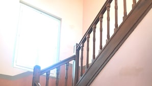 A wooden staircase with a handrail, a window at the top, and a wall with a baseboard. - La Poste (Hontanx)