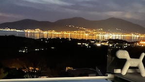 A nighttime cityscape with a body of water and mountains in the background. - Contemporary, single-story villa with an exceptional view of the Gulf of Ajaccio, (Albitreccia)