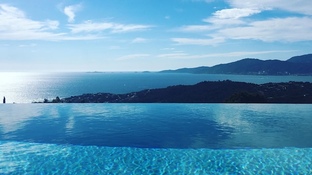 A clear view of an infinity pool with a mountain and ocean in the background. - Contemporary, single-story villa with an exceptional view of the Gulf of Ajaccio, (Albitreccia)