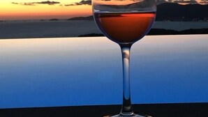 A wine glass on a table with a sunset view. - Contemporary, single-story villa with an exceptional view of the Gulf of Ajaccio, (Albitreccia)