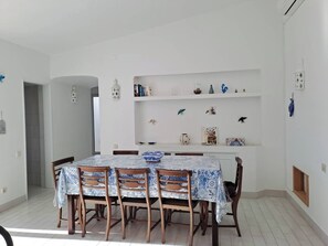A dining area with a table set for four, surrounded by wooden chairs. - House with private pool, air conditioning, near beach (Olhos de agua)