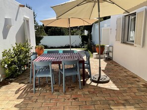 Eine Terrasse mit Tisch, Stühlen, einem Pool und Kübelpflanzen.