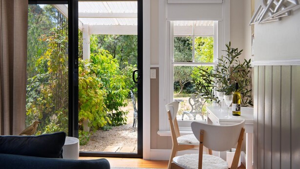 A modern kitchen with a dining area, a white table, and chairs.
