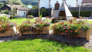 A garden with flower beds and a wooden bench.