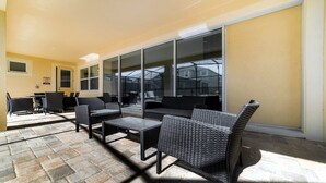 Ein möblierter Patio-Bereich mit Korbmöbeln, Tisch und Stühlen.