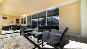 Ein möblierter Patio-Bereich mit Korbmöbeln, Tisch und Stühlen.