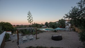 Un jardin avec une piscine, un espace salon extérieur et une pergola.