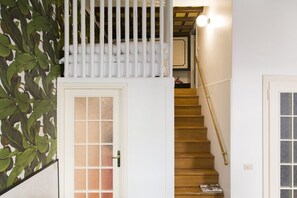 A staircase with a white door and a white railing, leading to an upper level.