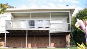 Un bâtiment à deux étages doté d’un balcon, de murs en briques et d’un toit plat.