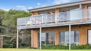 A two-story building with a balcony, large windows, and a brick facade. - Paradise Court 6, Tura Beach (Tura Beach)