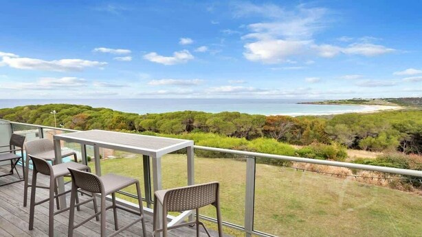 A deck with outdoor seating overlooking a beach and forested area. - Paradise Court 6, Tura Beach (Tura Beach)