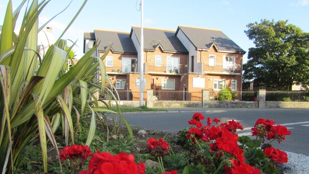 A residential building with a brick facade, multiple windows, and a gated entrance. - Town House, situated in the village Salthill close to the seafront. (Galway)