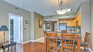 A spacious kitchen with wooden cabinets, a central island, and a dining area with a dark wooden table and chairs. - 10 Mi to Beach: Legends Resort Condo on Ninth Hole (Myrtle Beach)