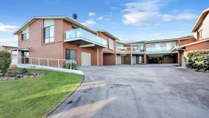 Ein Wohngebäude mit Garage, überdachter Auffahrt und kleinem Rasen.