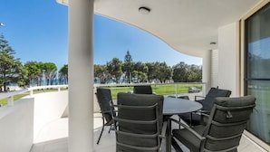 A balcony with a table and chairs, overlooking a golf course. - Byron Bay Accom - The Palms 4 - 54 Lawson Street (Byron Shire)