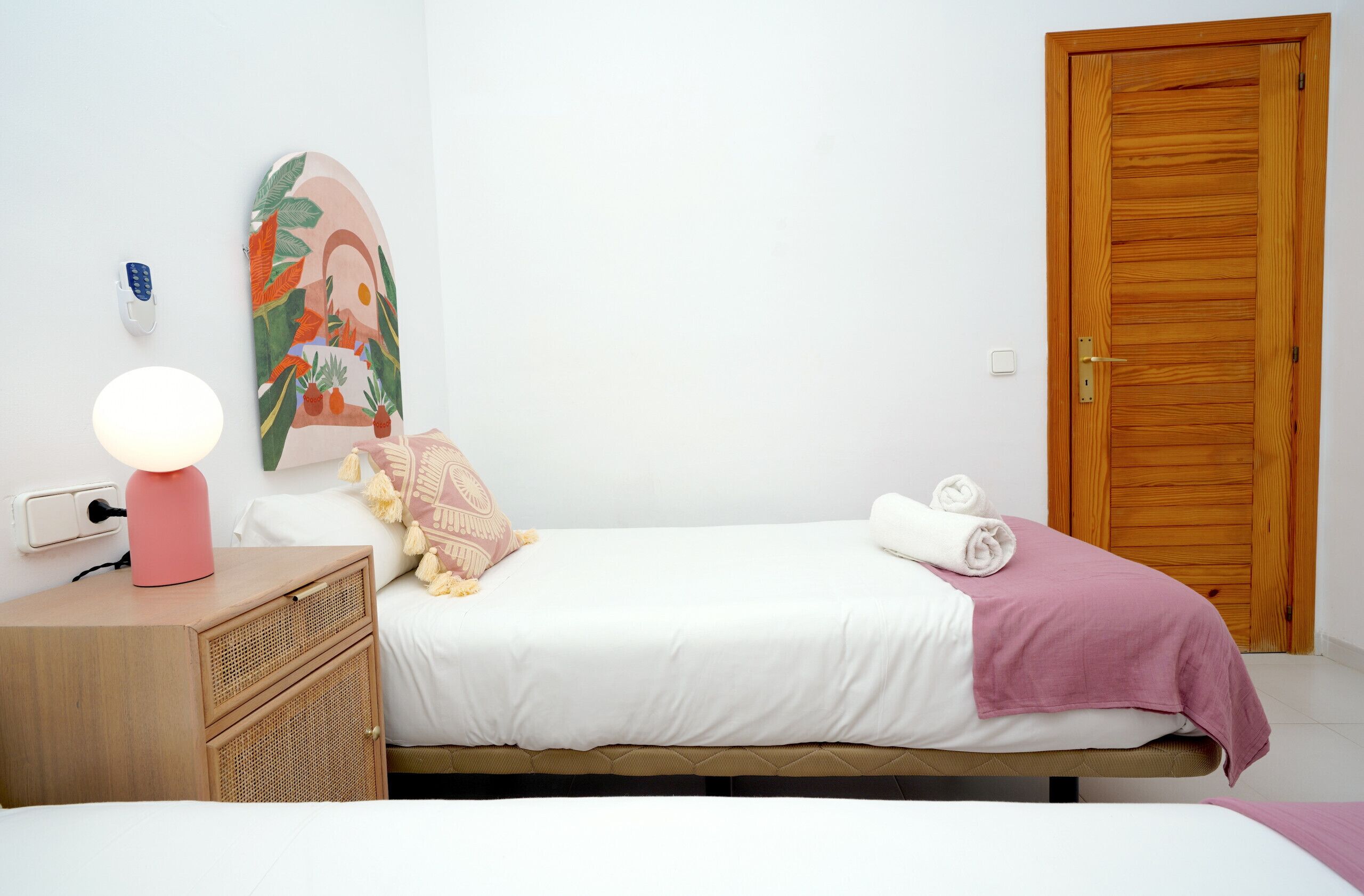 Ein Schlafzimmer mit einem Bett, einer Nachttischlampe und einer Holztür.