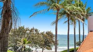 A beach with palm trees and a clear view of the ocean. - Byron Bay Accom - Beachbound 1 - 9 Marine Parade, Wategos Beach (Byron Shire)