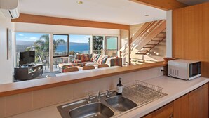 A modern kitchen with a built-in microwave, a double sink, and a view of the outdoors. - Seaview Pambula Beach (Pambula Beach)