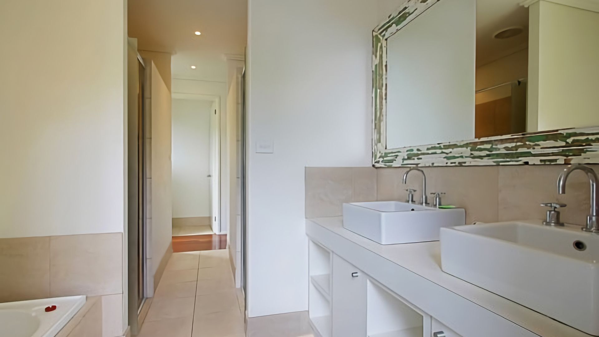 Un bagno moderno con due lavabi, un grande specchio e una zona doccia.