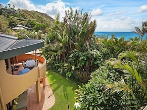 Relax in a serene ocean view setting with an outdoor seating area and lush garden.