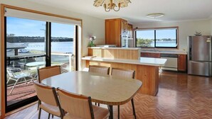 A modern kitchen with a central island, wooden cabinets, and a view of the water.