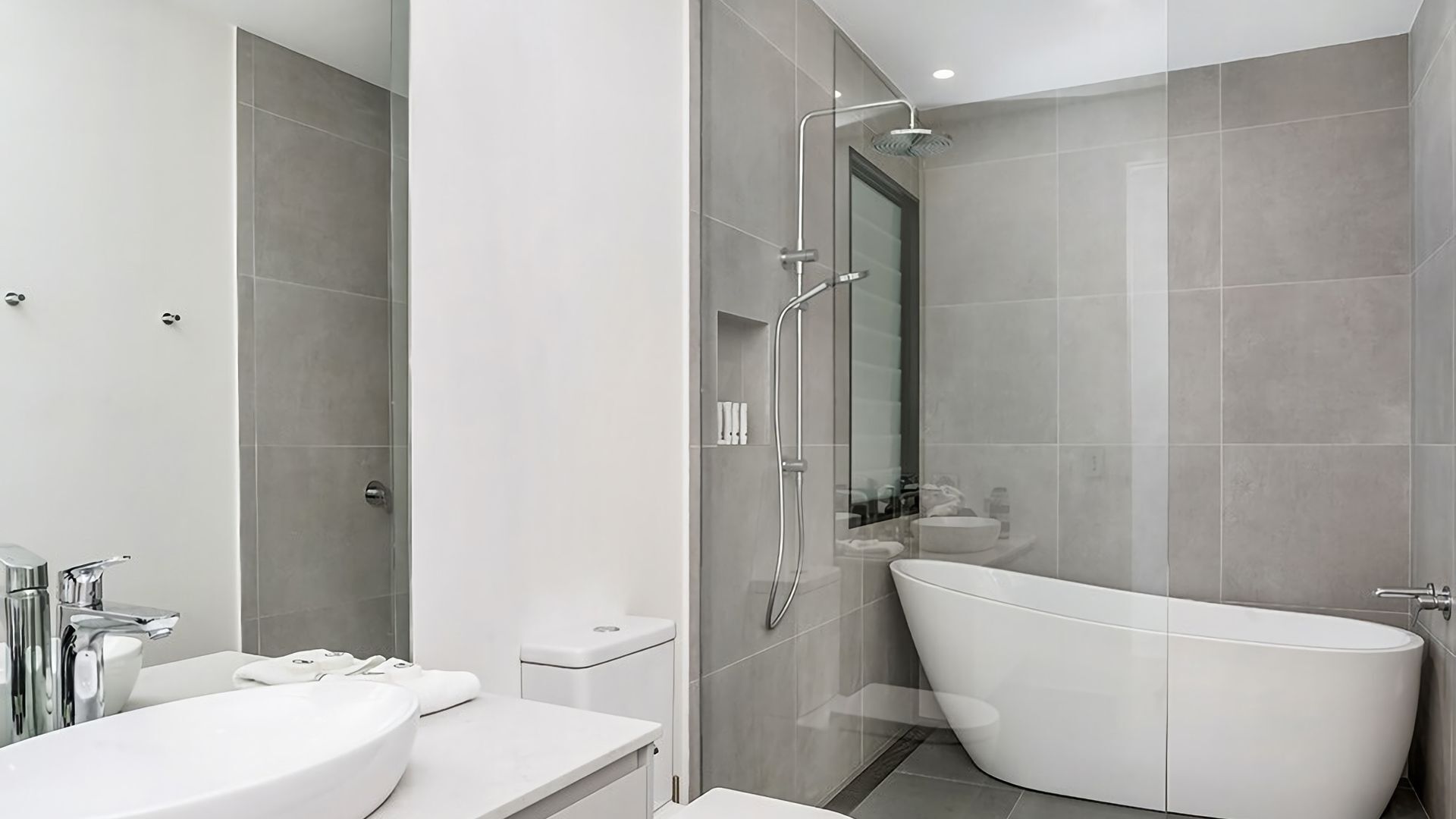 Een moderne badkamer met een vrijstaand bad, een aparte douche en een wastafelmeubel met een wastafel.