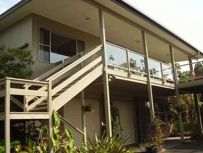 A two-story house with a covered front porch, a staircase, and a garage. - Deja Blue - Pambula Beach (Pambula Beach)