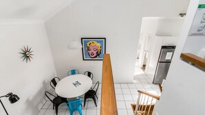 A modern kitchen with white cabinets, a stainless steel refrigerator, and a wooden countertop. - Byron Bay Accom - Balcony on Lawson - 6 - 34 Lawson Street (Byron Shire)