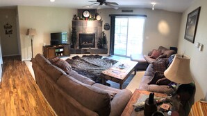 A living room with a fireplace, a sofa, a coffee table, and a television. - High Pines Hideaway  on Two Bit Springs Rd. (Deadwood)