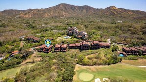 Un parcours de golf comprenant plusieurs bâtiments, notamment un hôtel à étages et un espace piscine.