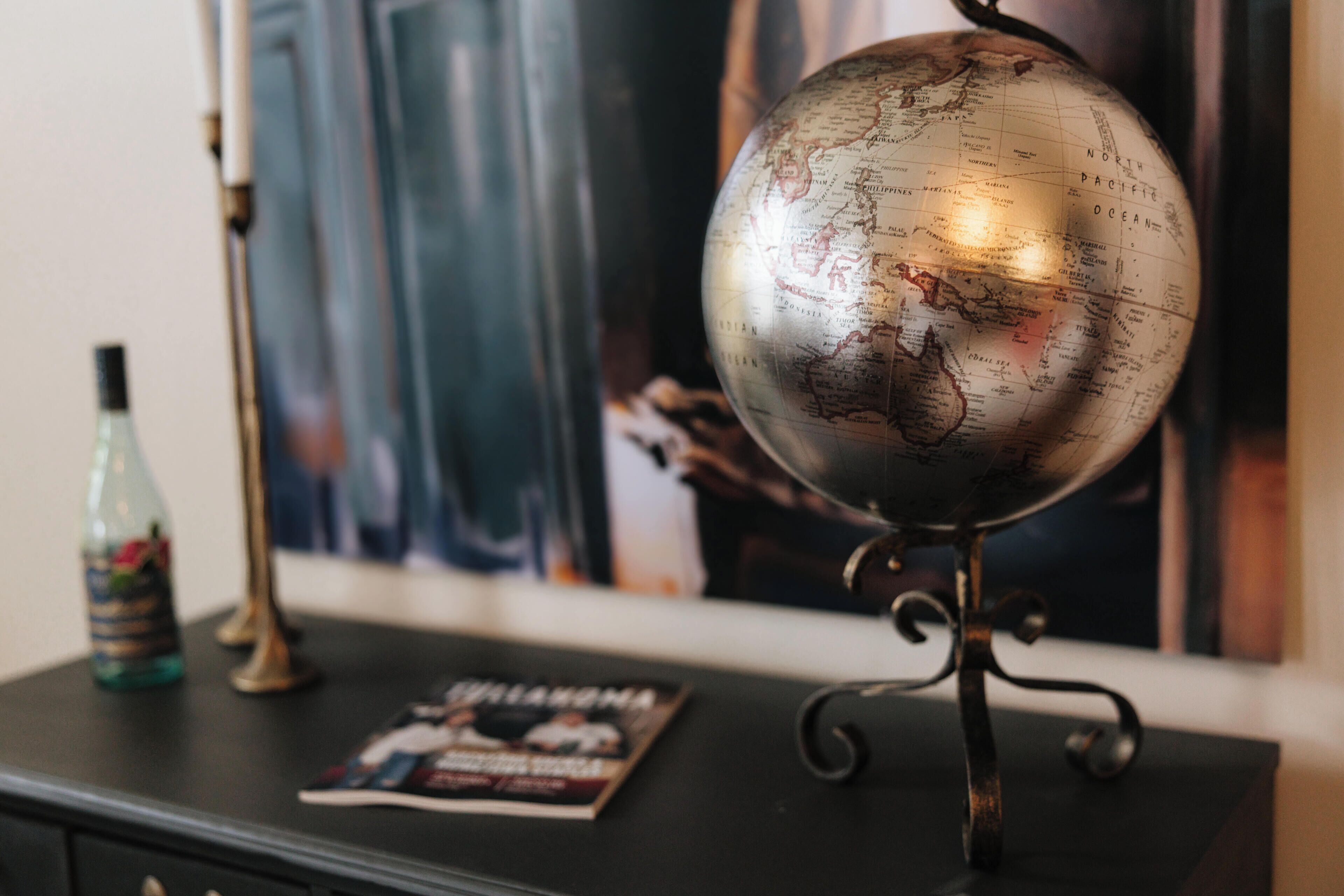 Un globo sobre un pedestal, una revista sobre una mesa y una botella.