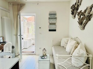 A bedroom with a bed, bedside table, and a wall with family rules.