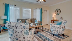 A living room with a sofa, armchair, coffee table, and a ceiling fan. - Keys Cove Villas - No 5 (Marathon)