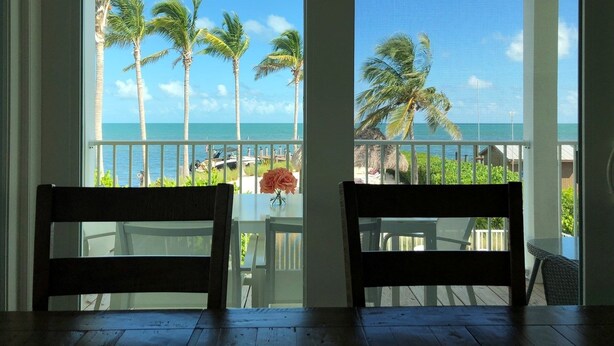 A balcony with a view of the ocean and palm trees. - Keys Cove Villas - No 6 (Marathon)