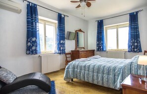 A bedroom with a bed, a dresser, a chair, a TV, and a ceiling fan. - La Terrazza di Laurino (Laurino)
