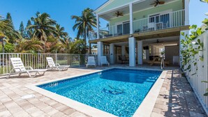 A rectangular swimming pool with a tiled edge, surrounded by a white fence and lounge chairs. - Keys Cove Villas - No 8 (Marathon)