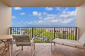 Un balcon donnant sur un paysage urbain, une table et deux chaises.