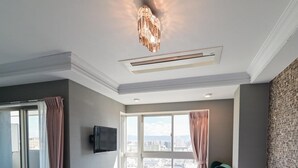 Une chambre d’hôtel avec deux lits, une télévision, une grande fenêtre avec des rideaux et une vue sur la ville.