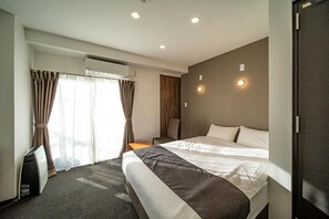 Una habitación de hotel con una cama, una mesita de noche, una lámpara y una ventana con cortinas.