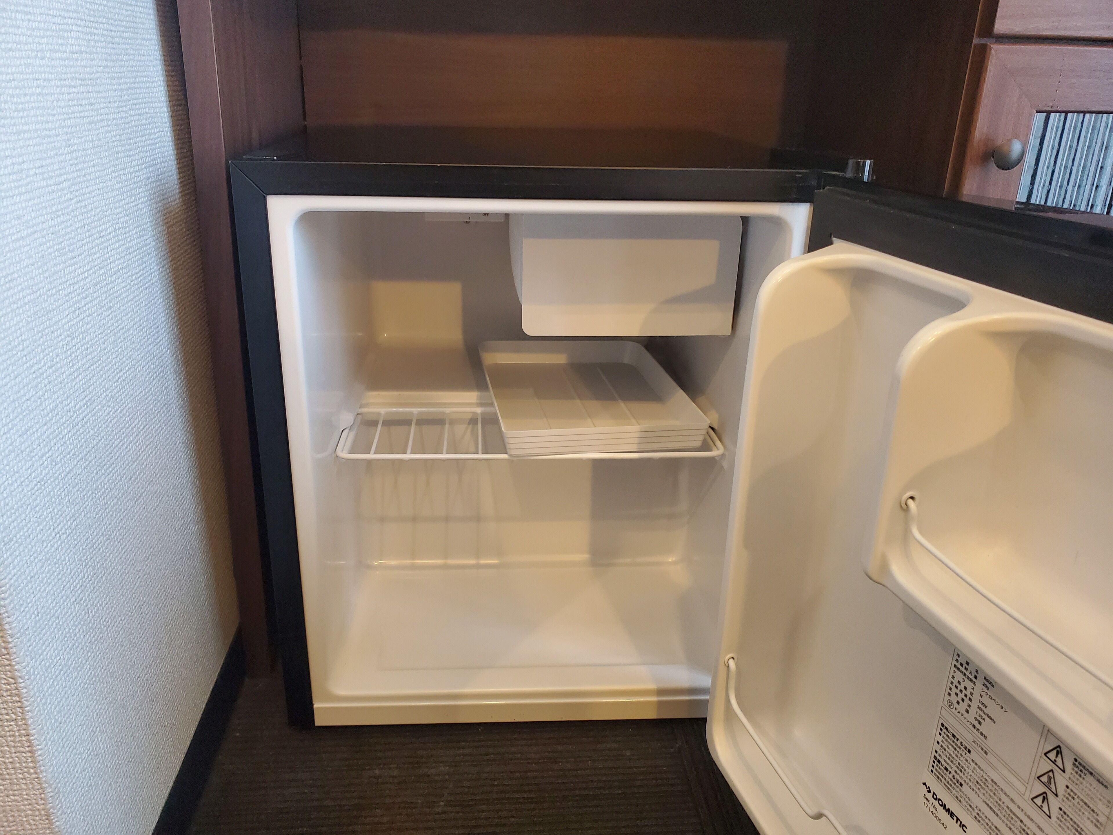 An open refrigerator with a shelf and a door handle.
