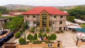 A building with a red roof and a central entrance. - NP Plaza Hotel (Akosombo)