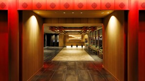 A hotel lobby with a central seating area, a reception desk, and a modern design with wooden paneling and a red accent wall. - Daiwa Roynet Hotel Nara Natural Hot Springs (Nara)